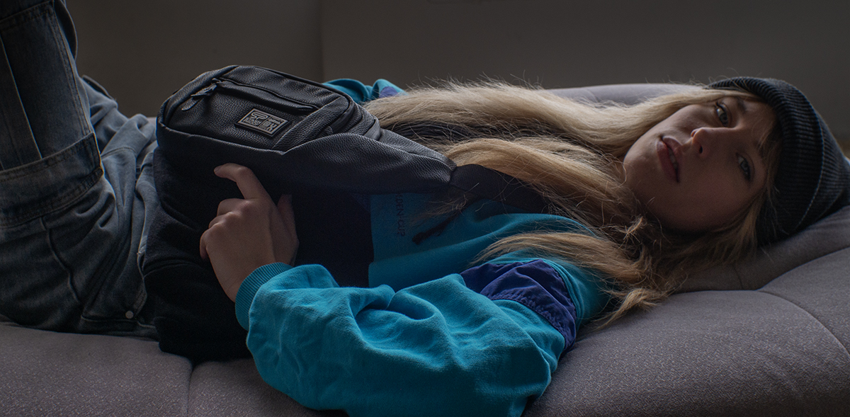 woman laying down with bag in dark lit room